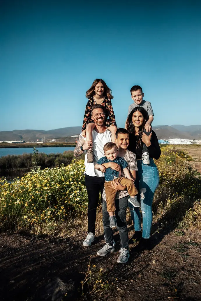 2 women and man standing on green grass field during daytime