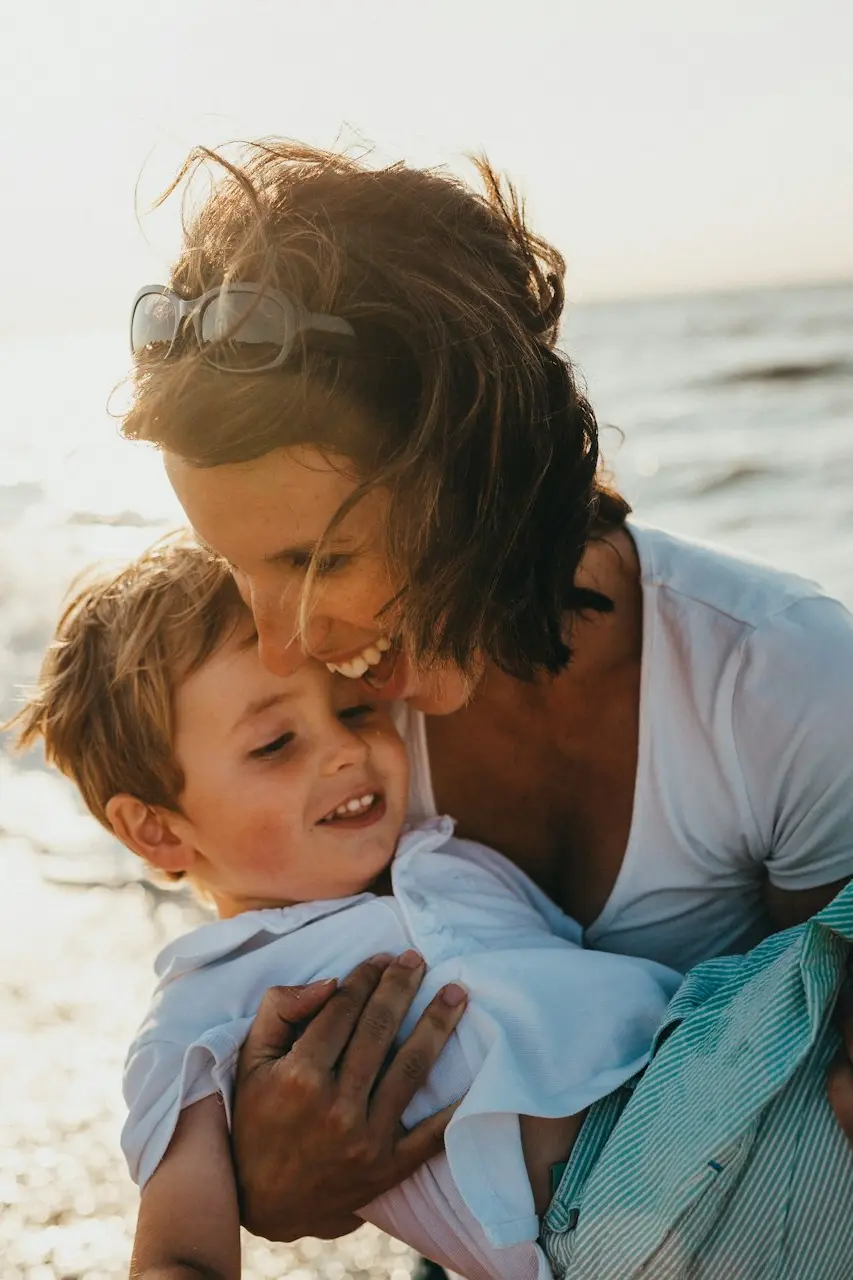 photo of mother and child beside body of water